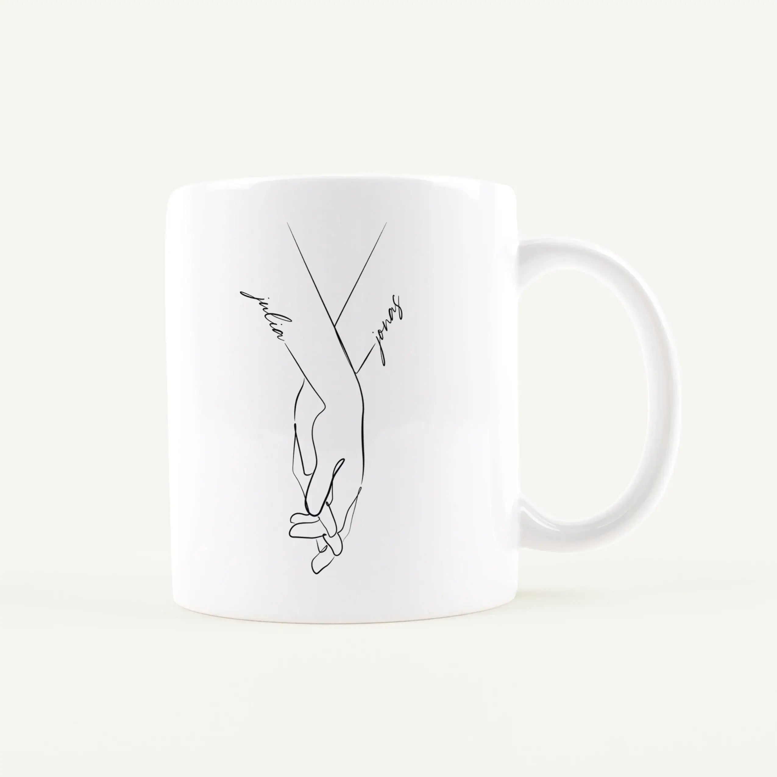 Tasse Hand in Hand-Keramik Tasse-famprints-Tasse Hand in Hand von famprints ist eine persönliche Tasse für Paare, die ein schlichtes Motiv mit Bedeutung suchen. Zwei ineinandergreifende Hände stehen für Verbundenheit, während die Namen direkt in das Desig