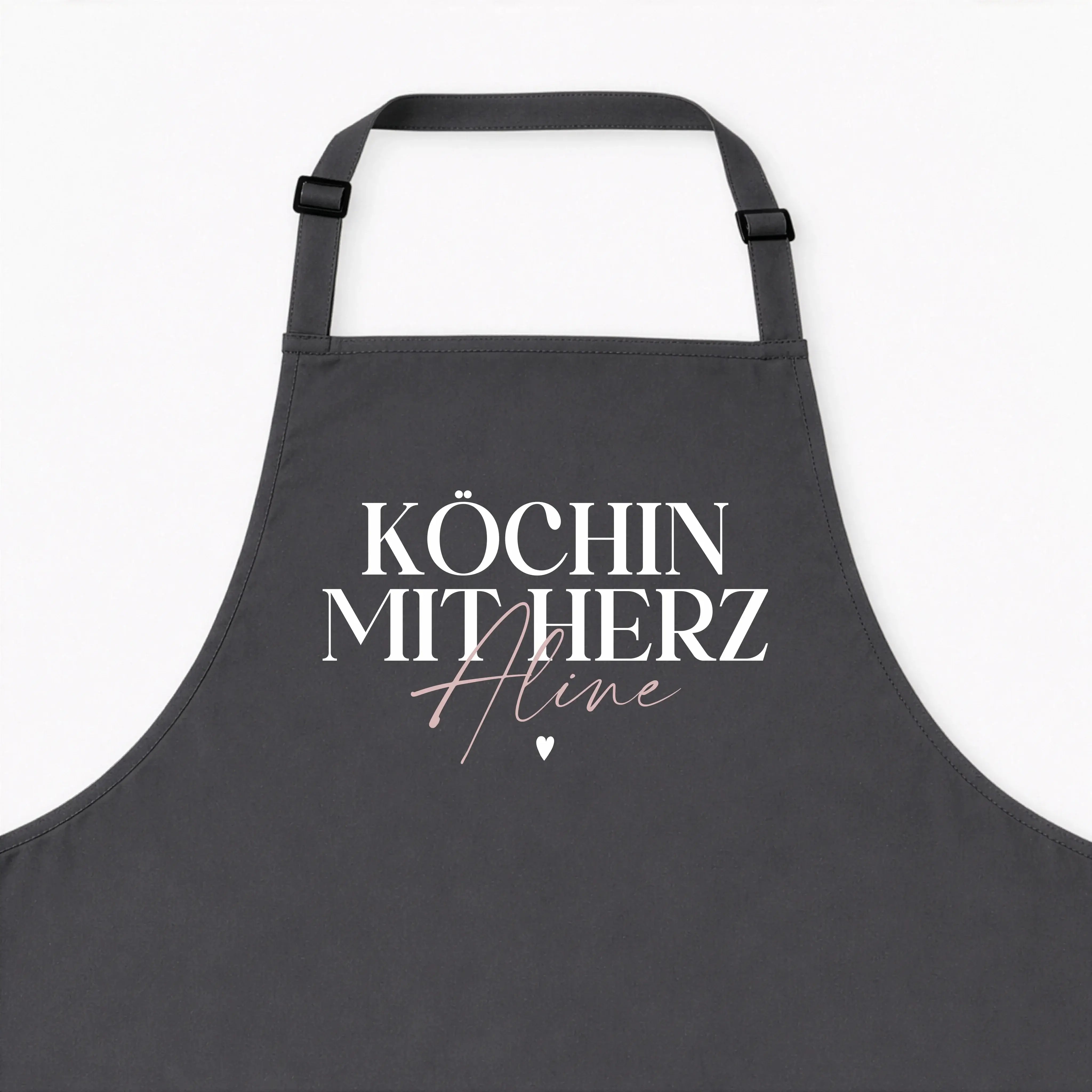 Kochschürze Köchin mit Herz--famprints-Die Kochschürze Köchin mit Herz von famprints ist mehr als nur ein praktisches Küchenaccessoire. Sie wird zu einem persönlichen Lieblingsstück, das Kochen, Backen und Zubereiten begleitet. Mit deinem Wunschnamen gest