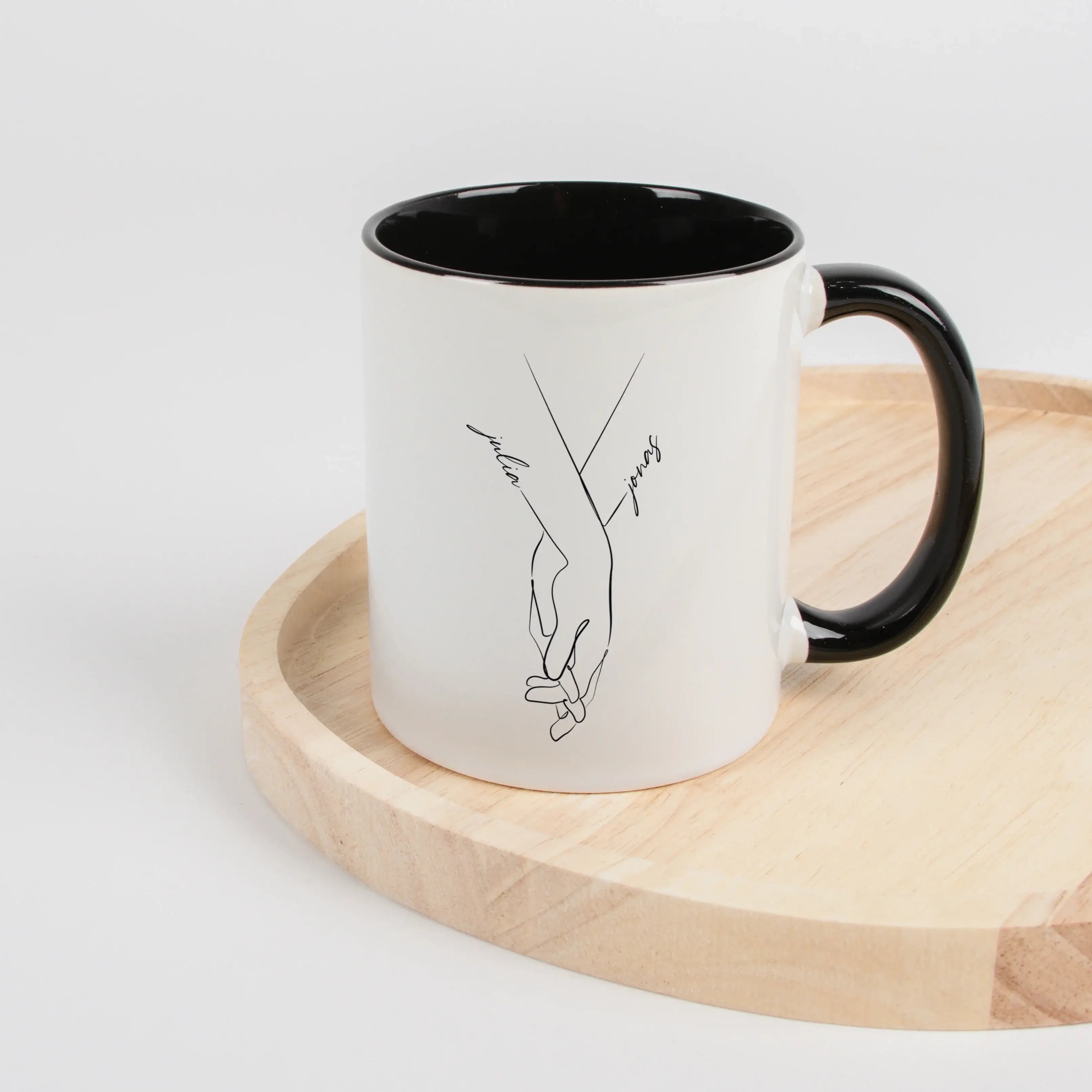 Tasse Hand in Hand-Keramik Tasse-famprints-Tasse Hand in Hand von famprints ist eine persönliche Tasse für Paare, die ein schlichtes Motiv mit Bedeutung suchen. Zwei ineinandergreifende Hände stehen für Verbundenheit, während die Namen direkt in das Desig