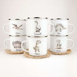 Emaille Tasse Dino-famprints-Emaille Tasse-Entdecke die bezaubernde Emaille Tasse Dino – ein persönliches Highlight für jedes Kinderherz! Mit einem süßen Dino in Aquarell-Optik und der Möglichkeit, den Namen deines Kindes darauf zu verewigen, wird diese T