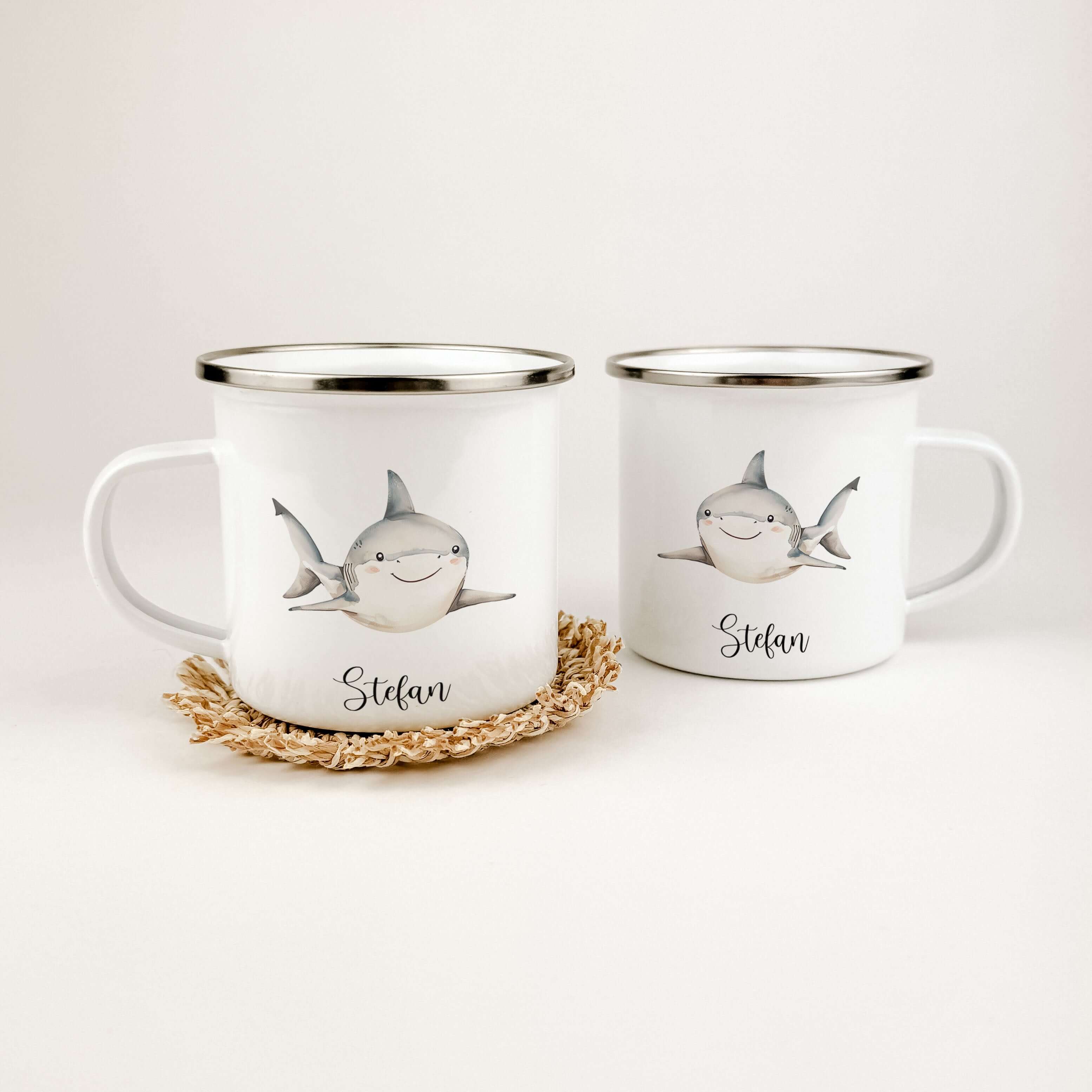 Emaille Tasse Hai-famprints-Emaille Tasse-Entdecke die perfekte Kindertasse für kleine Abenteurer! Unsere personalisierte Emaille Tasse mit einem bezaubernden Hai-Motiv in Aquarell-Optik bringt nicht nur Freude, sondern auch ein Stück Unterwasserwelt dire
